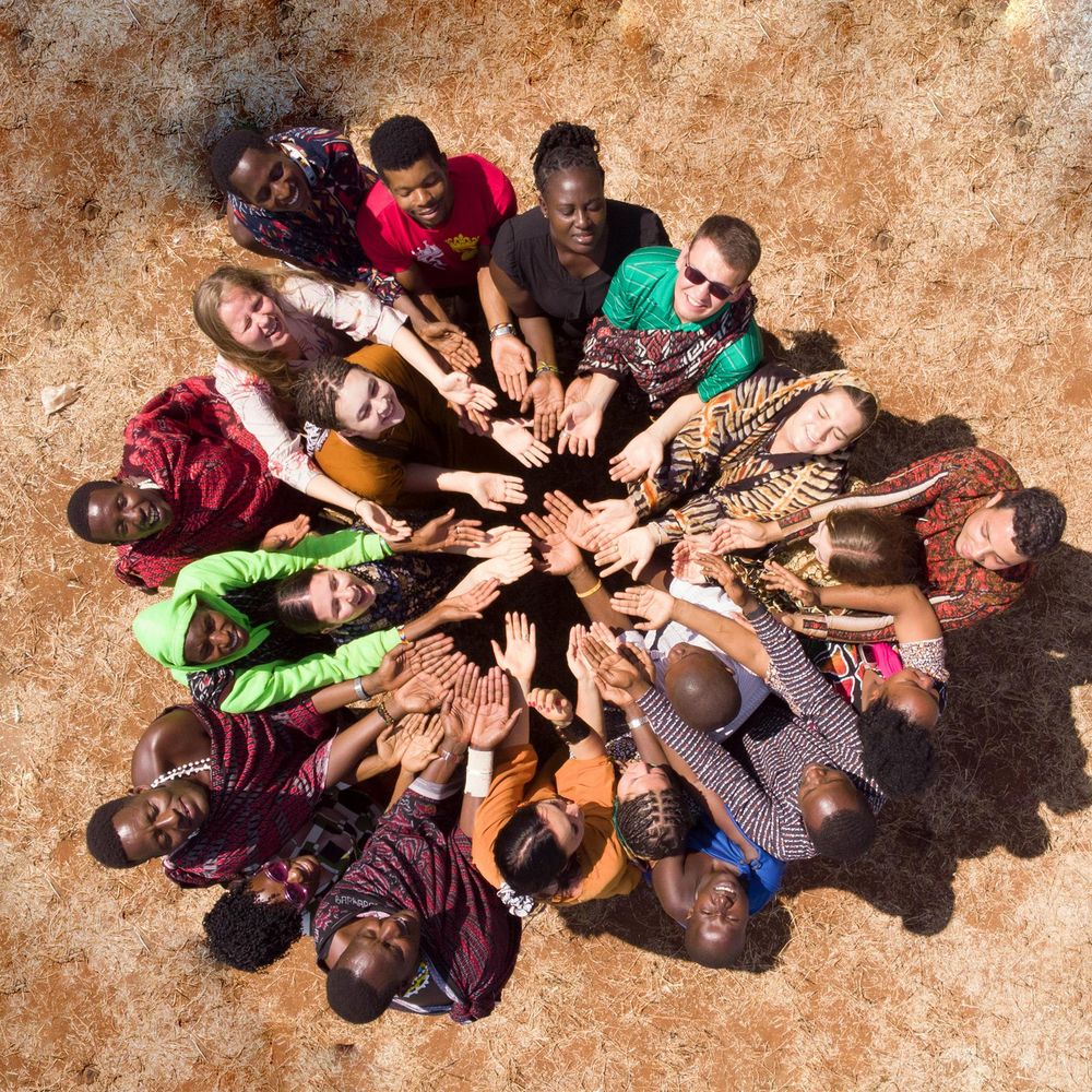 A group standing in a circle with their hands meeting in the centre